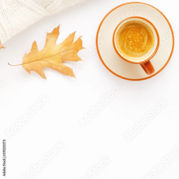 Obraz A Cup of coffee, a knitted blanket and autumn leaves on a white wooden background