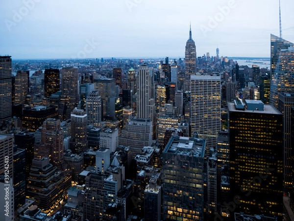 Obraz View of New York City from the top at night, Skyscrapers and buildings, afternoon lights, offices lights at the horizon, antennas on the roofs, human structures, city life
