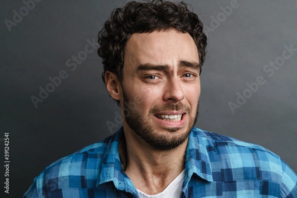 Obraz Unshaven scared guy posing and looking at camera