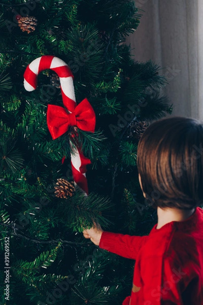 Obraz Child decorating the tree seen from behind