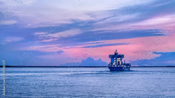 Obraz Vessel leaving Port of Antwerp during a colorful sunset, Antwerp, Flanders, Belgium.