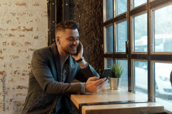 Obraz Happy young businessman with mobile phone
