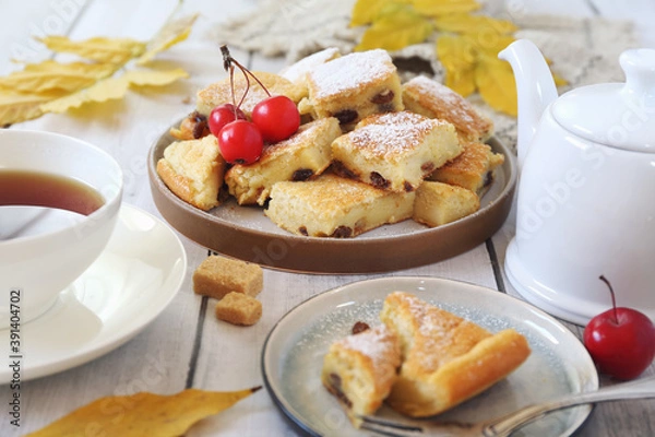Fototapeta Austrian cuisine.  Torn pancake (or omelet)  kaiserschmarrn with sultana, powdered sugar dressing and cup of tea for sweet breakfast