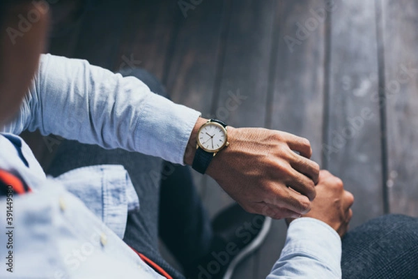 Fototapeta man fashionable wearing stylish looking at luxury watch on hand check the time at workplace.concept for managing time organization working,punctuality,appointment