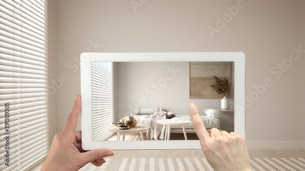 Fototapeta Augmented reality concept. Hand holding tablet with AR application used to simulate furniture and design products in empty interior with ceramic tiles. Living room, sofa, tables