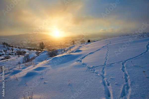 Obraz January landscape in the mountains. The sun rises from behind the mountain in winter