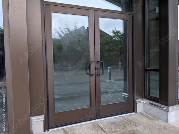 Fototapeta front doors for a business still under construction and locked with a padlock key in a shopping complex