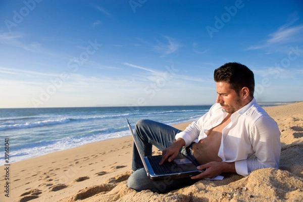 Obraz working in the laptop at the beach
