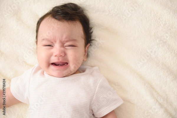 Obraz Top view of cute little Asian baby crying with copy space