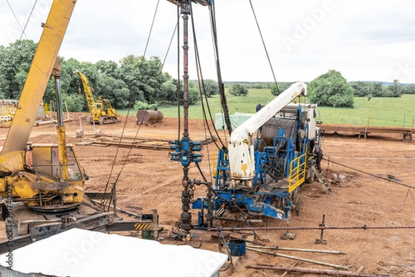 Fototapeta Coiled tubing unit doing well clean out. Wireline equipment hanging from top drive ready to be lowered downhole for logging.