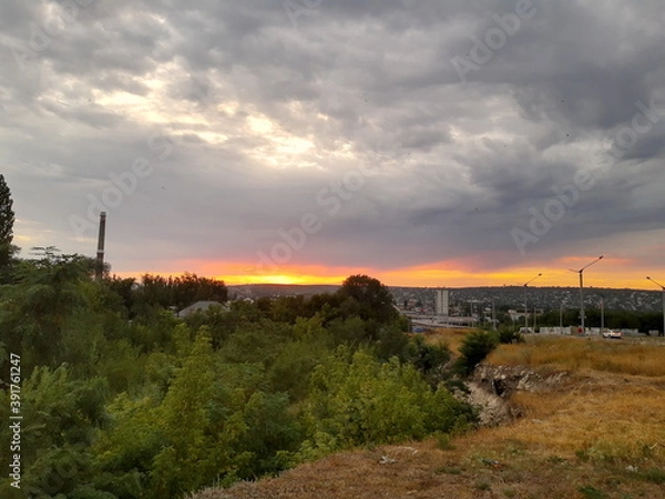 Fototapeta sunset with clouds on the background of the city