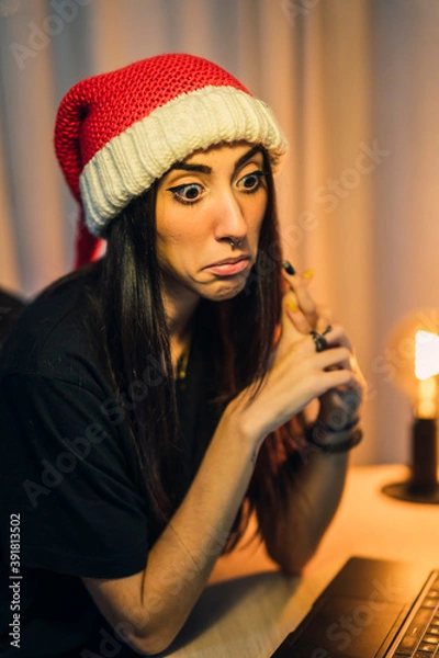 Fototapeta Chica con gorro de papa noel realizando vlog en su cuarto y trabajando en el pc