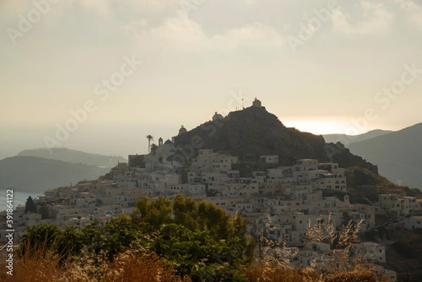 Fototapeta View at Ios main village or Chora at sunset time from a viewpoint in the mountain above, Ios island, Greece