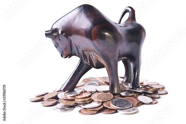 Fototapeta A strong, triumphant bull atop a pile of coins, signifying an op