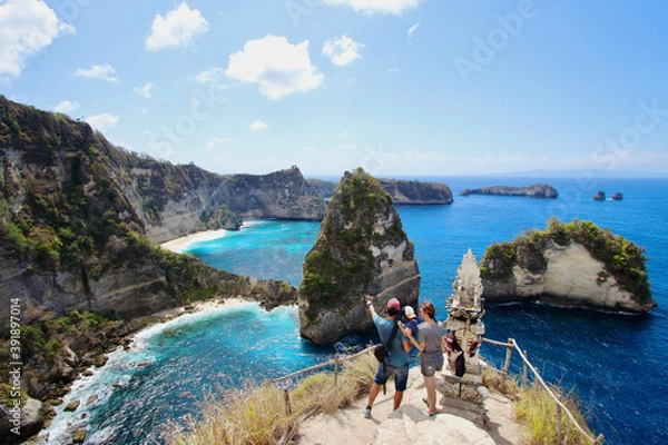 Fototapeta Young parents and little kid enjoying the views in Thousand Islands Viewpoint, on of the most amazing spots in Nusa Penida Island, Indonesia, Bali.