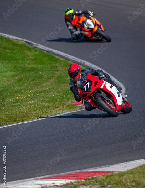 Fototapeta A shot of two racing bikes cornering on a track.