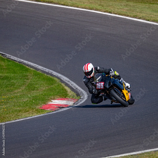 Fototapeta A shot of a racing bike cornering on a track.