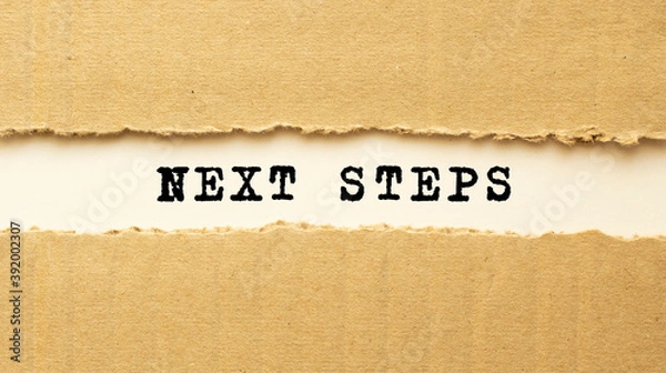 Fototapeta Text NEXT STEPS appearing behind torn brown paper. Top view.