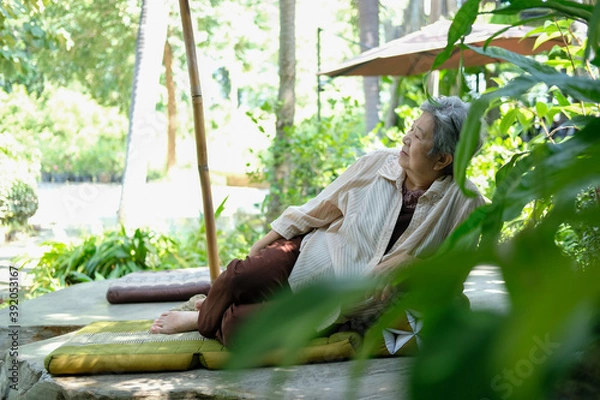 Fototapeta elder woman resting in garden. elderly female relaxing outdoors. senior leisure lifestyle