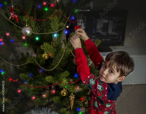Obraz little child decorating christmas tree
