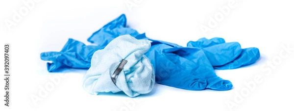 Fototapeta used surgical mask and blue latex surgical gloves on white background. the problem of disposal of medical waste and environmental pollution. End of quarantine. Covid-2019.