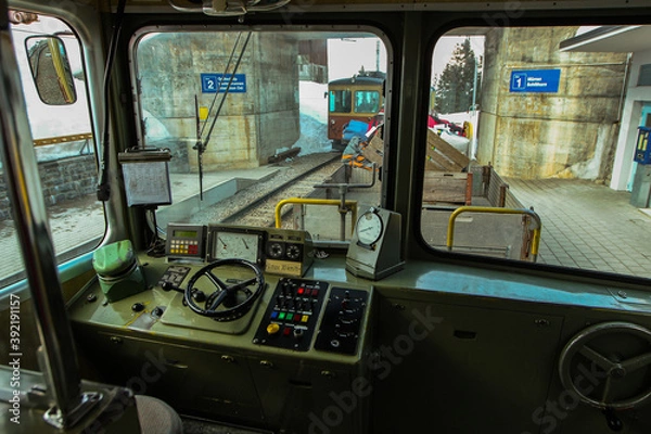 Fototapeta Driver cabin of narrow gauge train in Murren, connecting villages in Lauterbrunnen valley standing on a station. A lot of snow around in winter time.