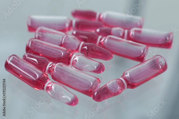 Fototapeta Ampoules with covid vaccine on a glass table