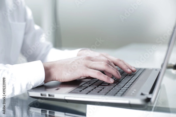 Fototapeta The manager works at the computer in the office