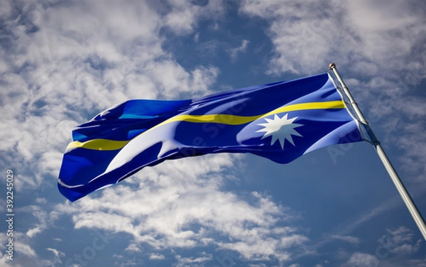 Fototapeta National state flag of Nauru fluttering at sky background.