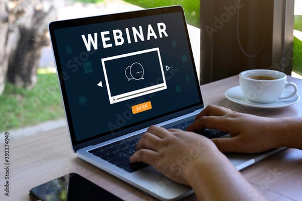 Fototapeta Person using a laptop computer for online training webinars. E-learning browsing connection and cloud online technology webcast concept. Laptop mockup with clipping path on screen