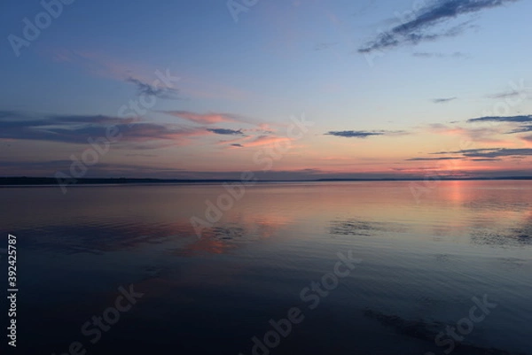 Fototapeta Twilight glow in the clear sky on the horizon above the calm water surface