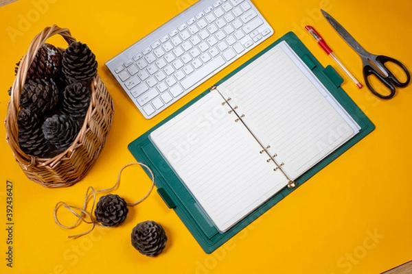 Obraz open notebook journal with Christmas cones in a wicker basket yellow background