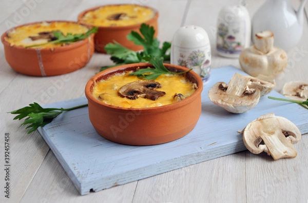 Fototapeta Homemade mushroom julienne in ceramic cocotte. Sliced champignons. Porcelain salt shaker.