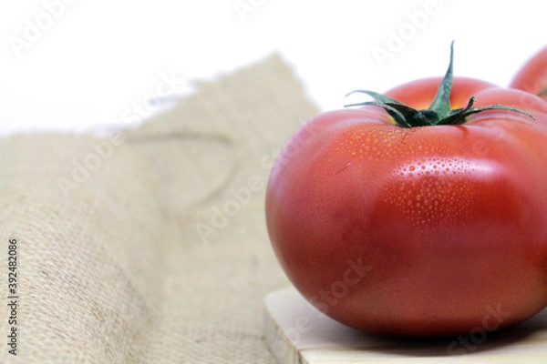 Obraz tomatoes on a wooden table with white background