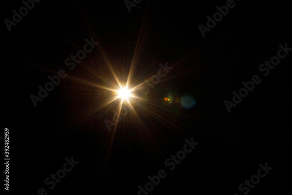 Fototapeta Easy to add lens flare effects for overlay designs or screen blending mode to make high-quality images. Abstract sun burst, digital flare, iridescent glare over black background.