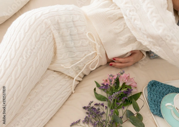 Obraz Woman dressed on a comfortable wool loungewear laid on bed.