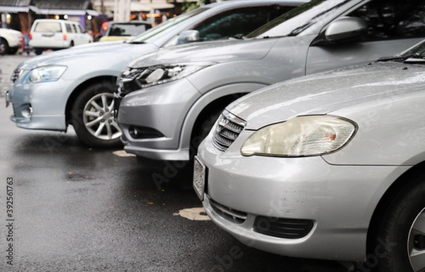 Fototapeta Zbliżenie z przodu samochodu z brązu i innych parkingów na odkrytym parkingu.