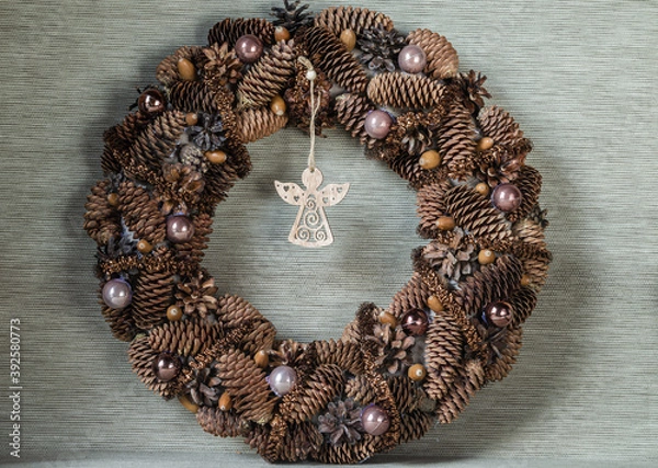 Fototapeta Christmas wreath in natural style with a figurine of an angel on a gray background close-up