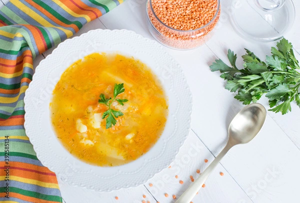 Fototapeta Delicious homemade red lentil soup in a white plate. Healthy vegan food.