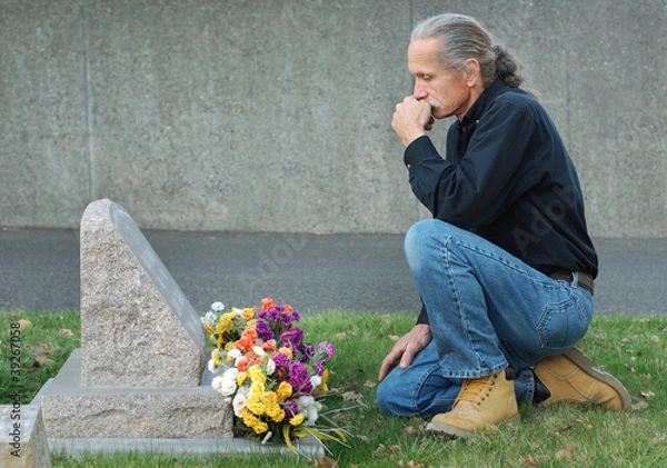 Obraz Man sitting at gravesite