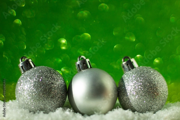 Obraz Minimalist Christmas concept: silver Christmas balls in a row, green glitter background, selective focus, free copy space