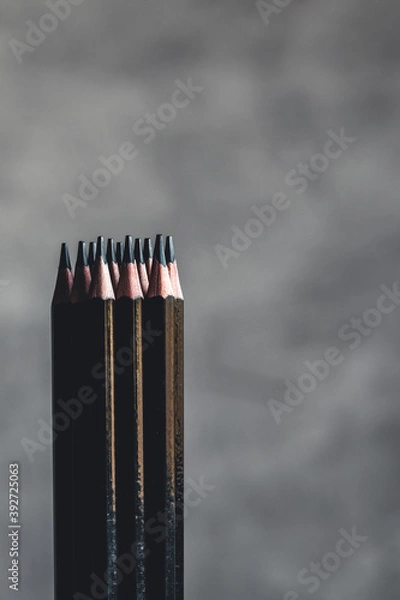 Fototapeta Simple graphite pencils on grey background. Black pencils, space for text