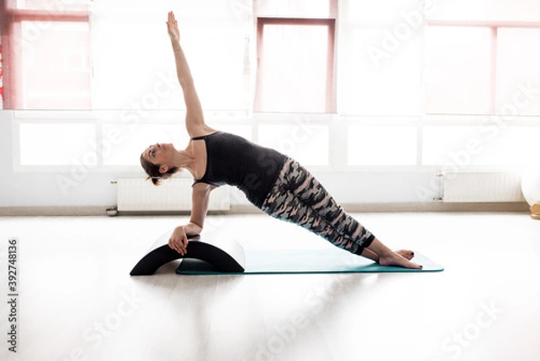Obraz Young person practicing yoga, standing in the Utthita Trikonasana variant exercise, prolonged triangular pose, exercising, wearing sportswear