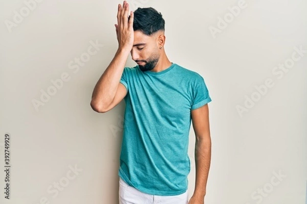 Fototapeta Young man with beard wearing casual clothes surprised with hand on head for mistake, remember error. forgot, bad memory concept.