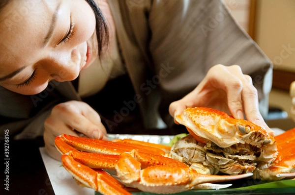 Fototapeta かにの甲羅を開ける女性の手元