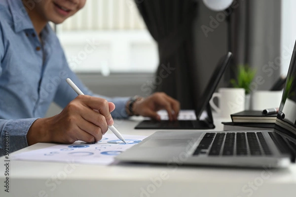 Fototapeta Cropped shot of a trader Man is monitoring annual business report in the office at the workplace.