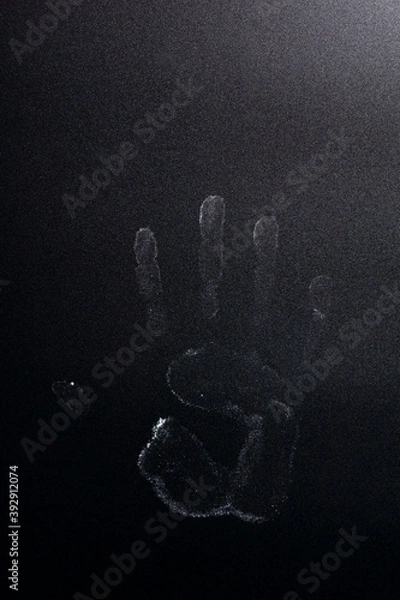 Fototapeta The imprint of the palm of the hand on a dark background.