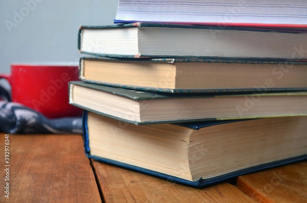 Fototapeta A stack of old books with yellowed pages, textbook, training, encyclopedia. Reading, knowledge. Library.