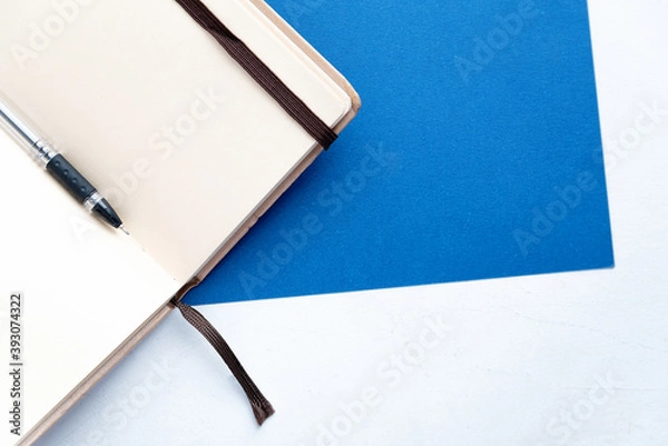 Fototapeta black pen rests on an open notebook