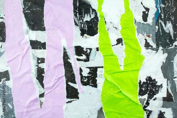 Fototapeta Torn and crumpled purple and green posters glued on billboard with old dirty paper. Abstract and creative background of ripped magazine paper.